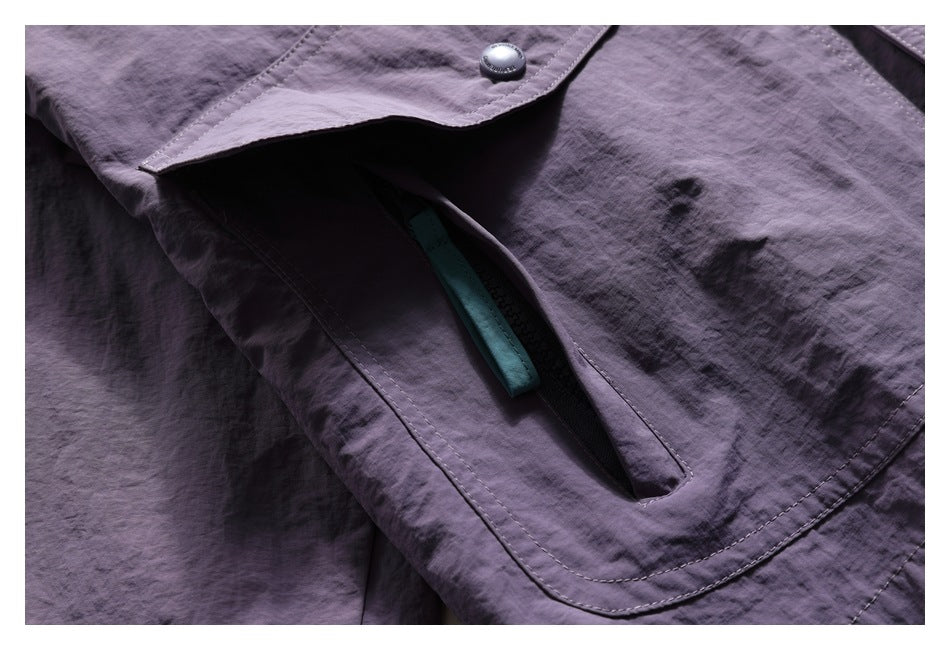 Close-up of the purple jacket's pocket opening beneath a snap flap, with turquoise trim visible inside.