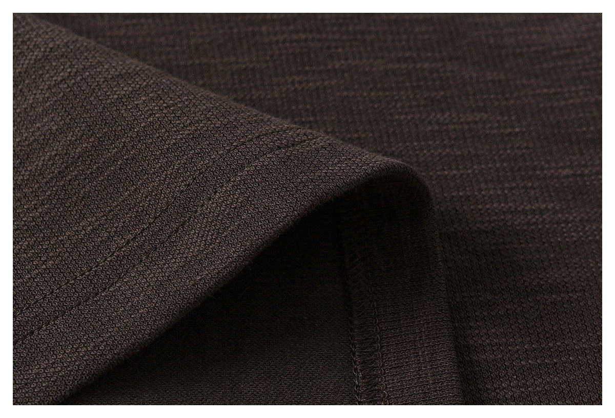 Close-up of dark brown knit fabric folded to show a stitched garment edge.