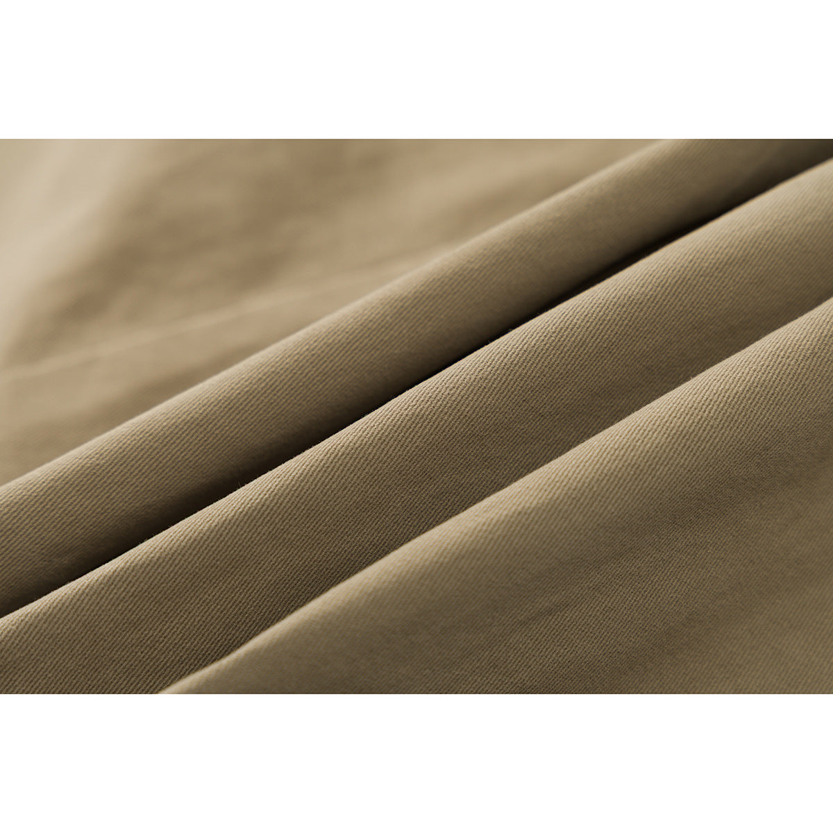 Macro view of the fine diagonal texture on khaki-colored shorts fabric.