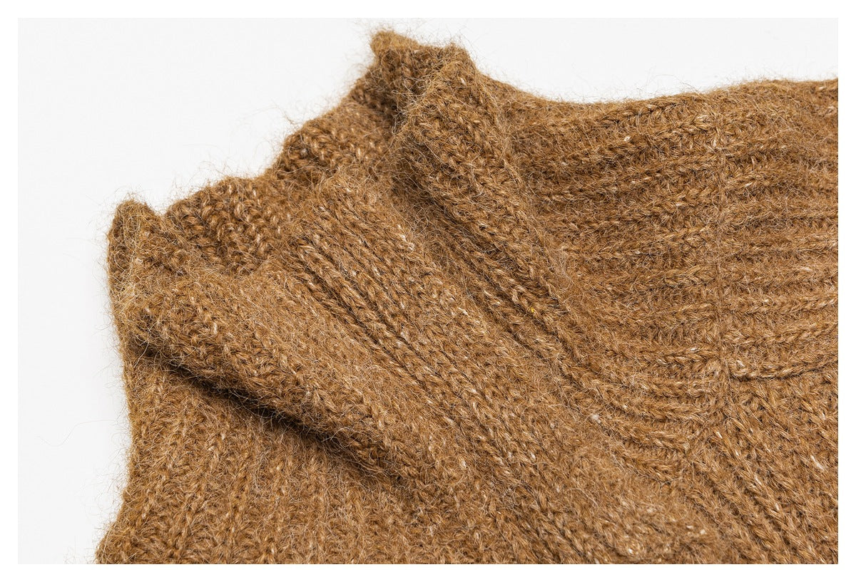 Close-up of the brown fuzzy knit garment's folded neckline and shoulder seam.