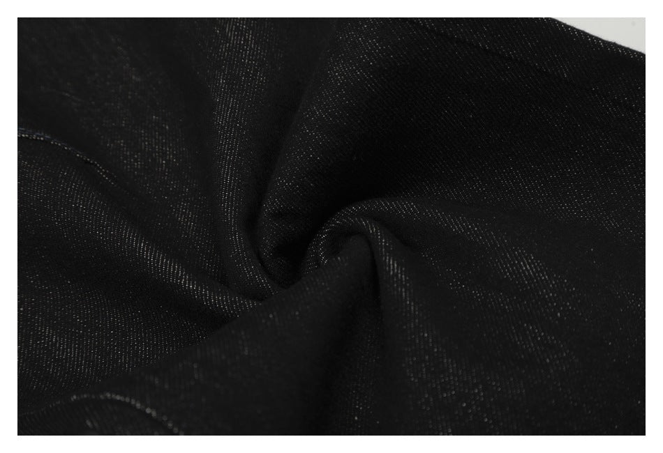 Close-up of black denim gathered to show its texture and drape.