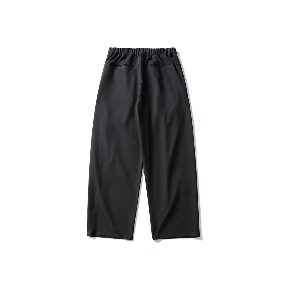 Back view of black wide-leg trousers with an elastic waistband and two rear pockets.