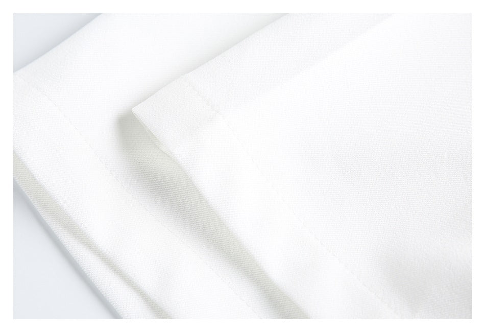 Close-up of layered white garment panels with a stitched edge.