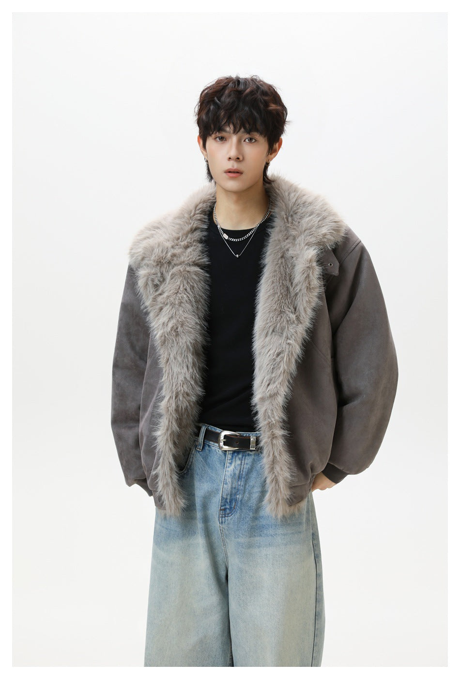 Model wearing a gray suede-look jacket open with a wide fluffy fleece-like collar over a black top and light-wash jeans