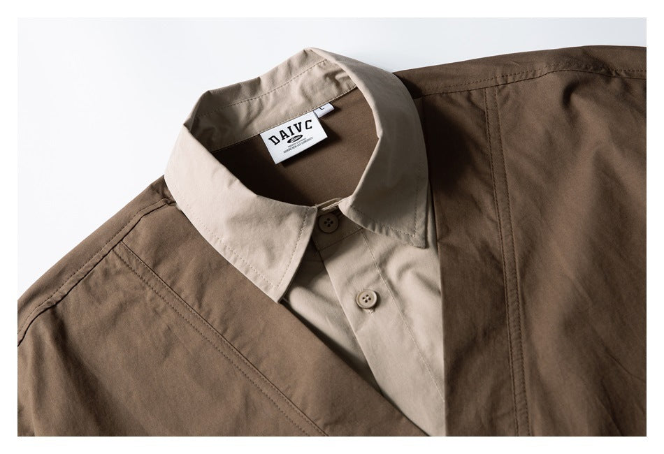 Close-up of a brown utility vest layered over a beige shirt, showing the collar, buttons and neck label.