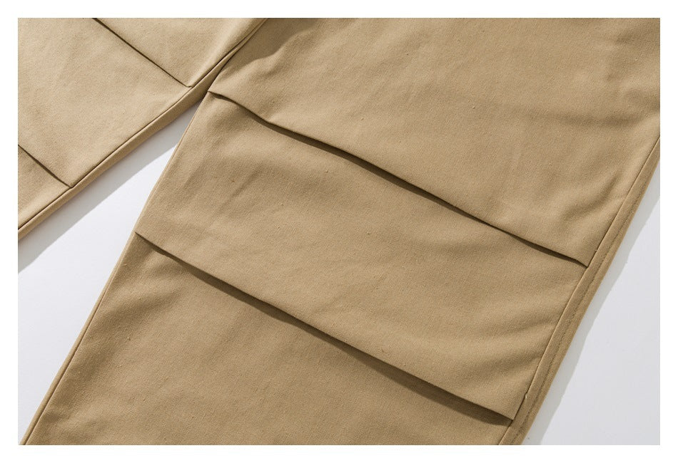 Close-up of tan pants showing layered horizontal fabric panels on the leg.
