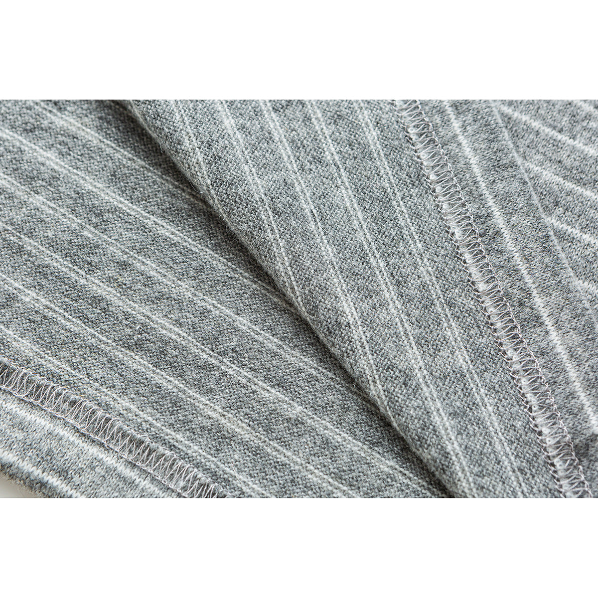 Close-up of gray striped knit fabric showing the inside and overlocked seam stitching.