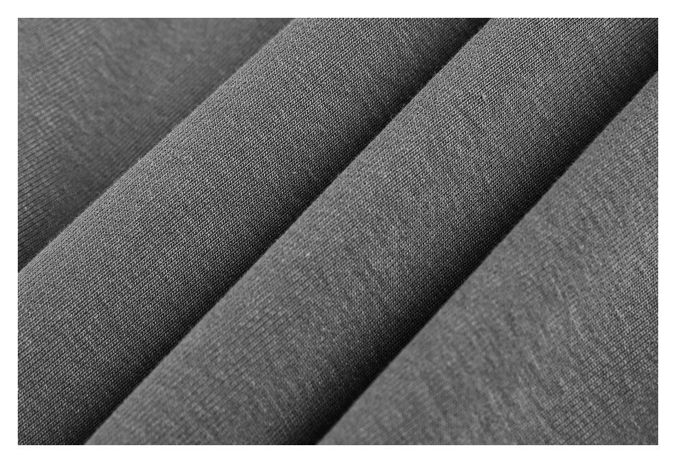 Close-up of dark gray fabric folded in layers, showing a fine textured surface.