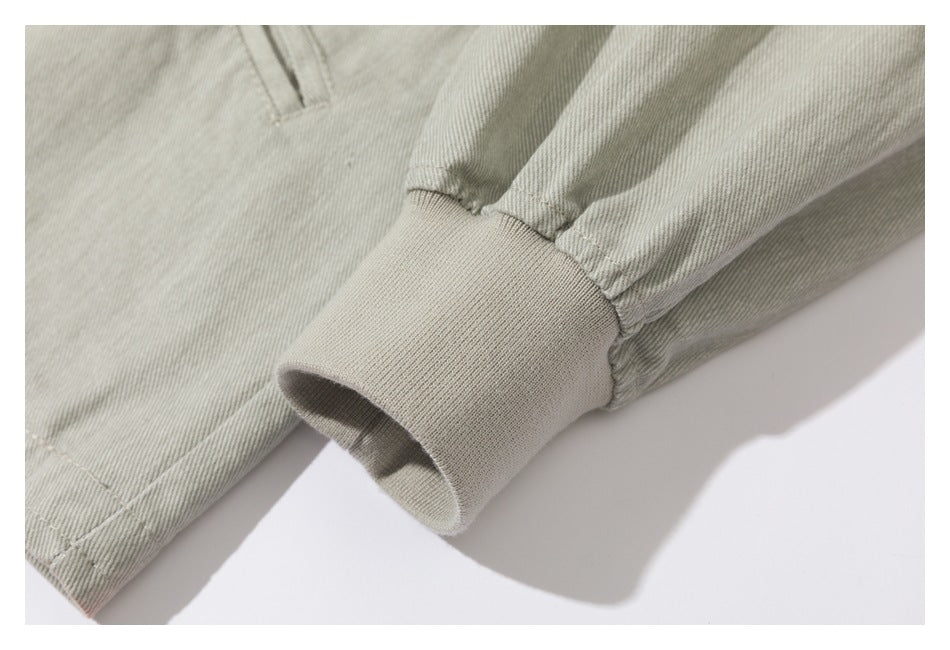 Close-up of a pale gray-beige sleeve gathered into a wide ribbed knit cuff.