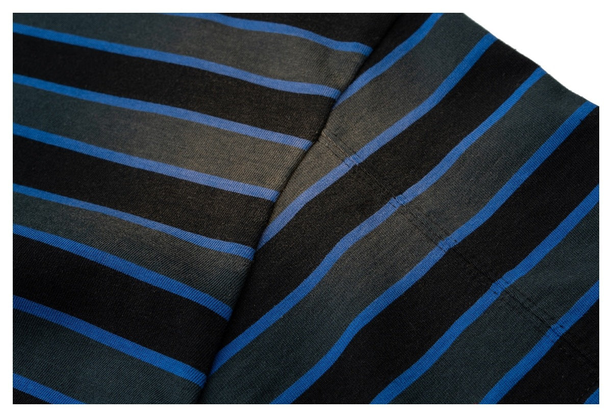 Close-up of the striped shirt's sleeve and body seam, with black, charcoal, and blue bands.