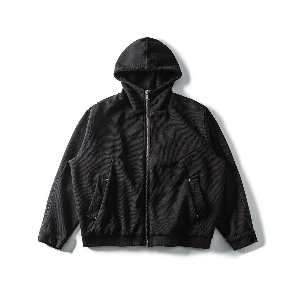 Black hooded zip-up jacket laid flat, front view, with textured fabric, ribbed hem and angled pockets with metal studs
