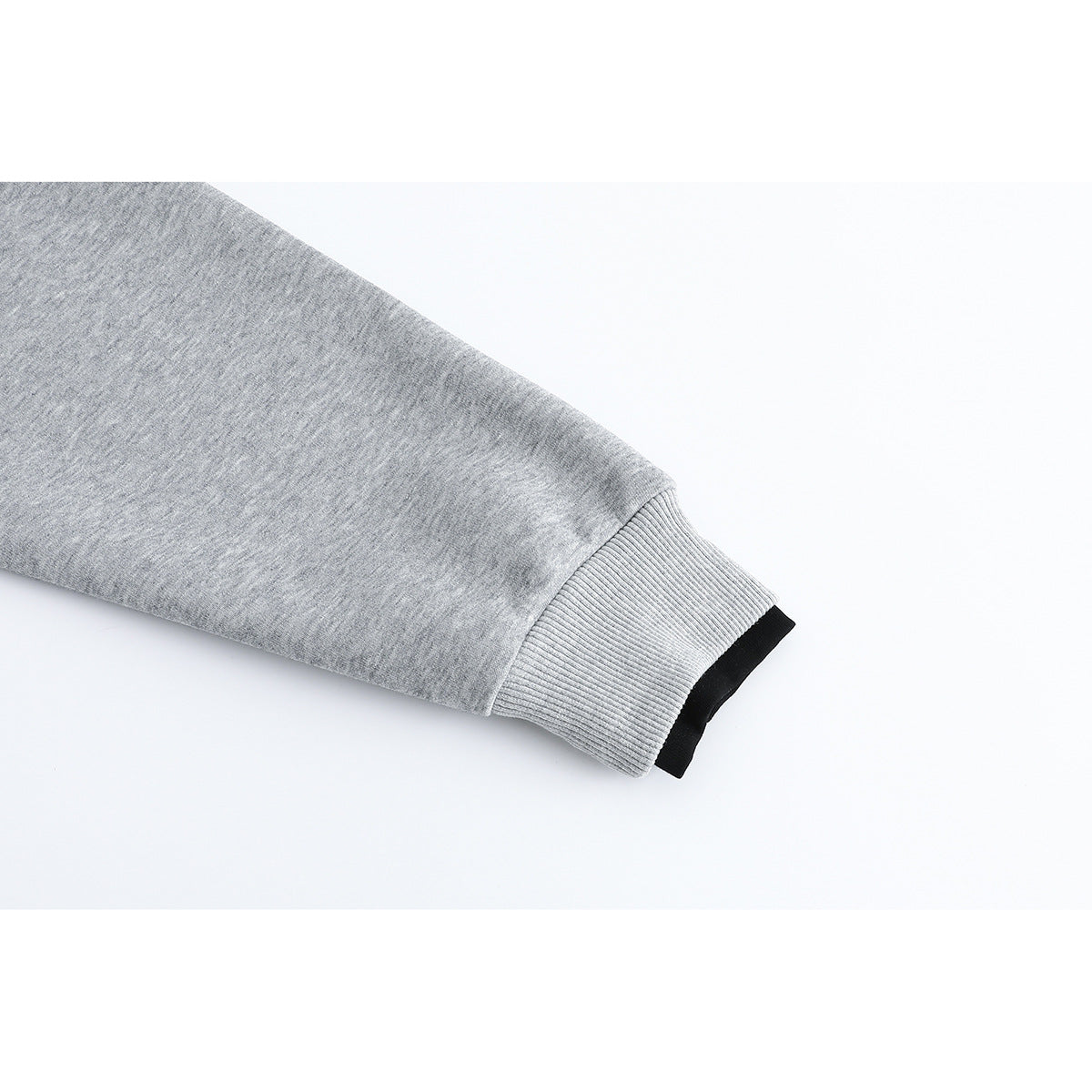 Close-up of a heather-gray sweatshirt sleeve ending in a wide ribbed cuff with a black inner edge.