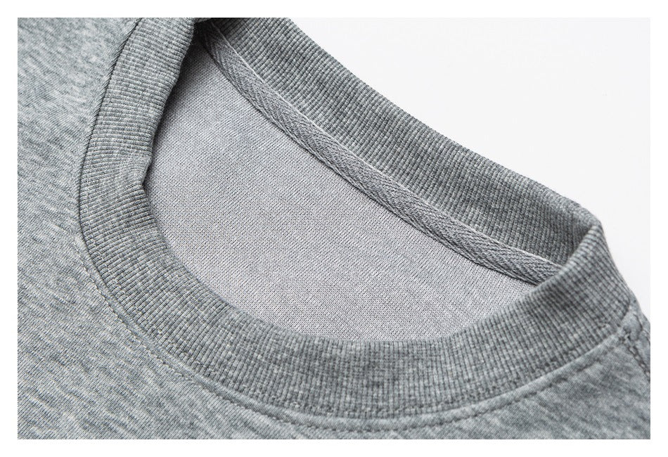 Close-up of the ribbed crew neckline and inner seam of a heather gray sweatshirt.