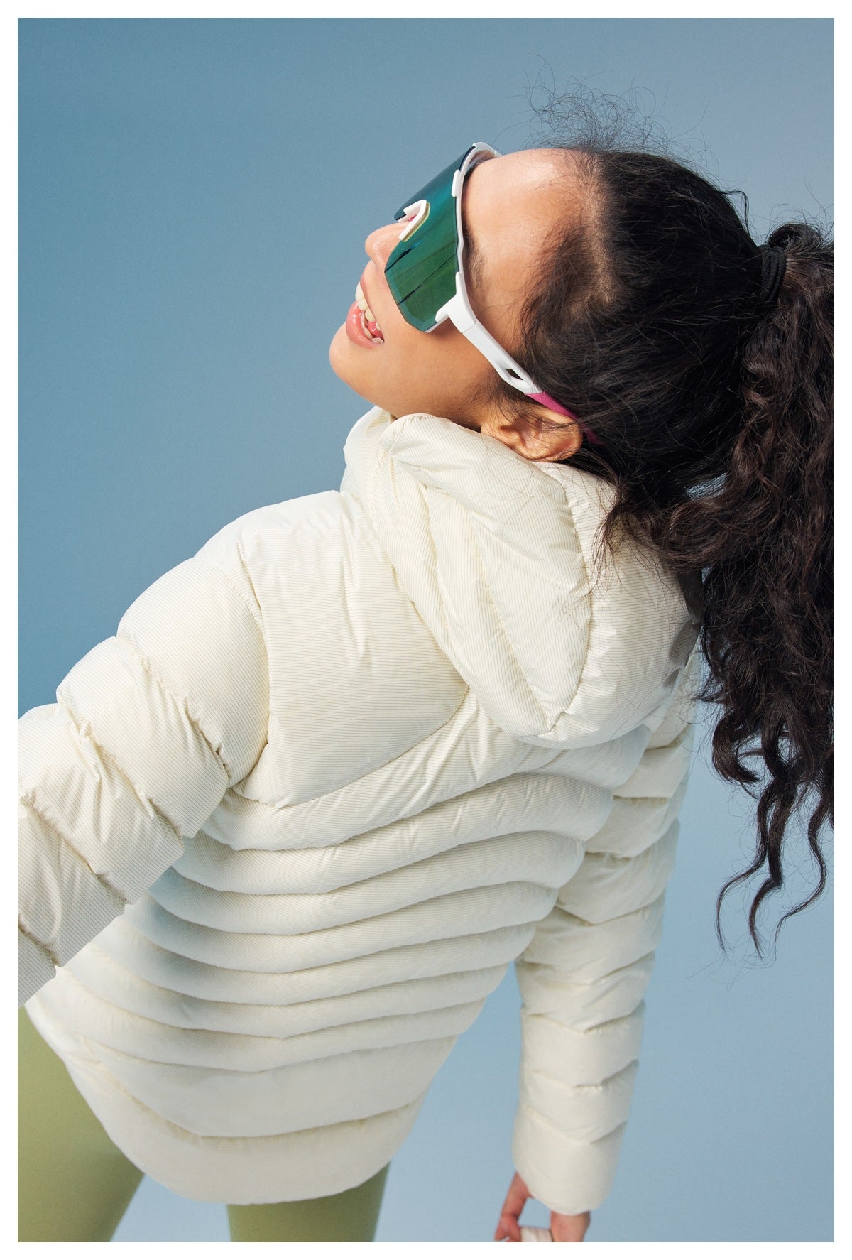 Model in a cream quilted puffer jacket with a high collar, shown from the side and back.