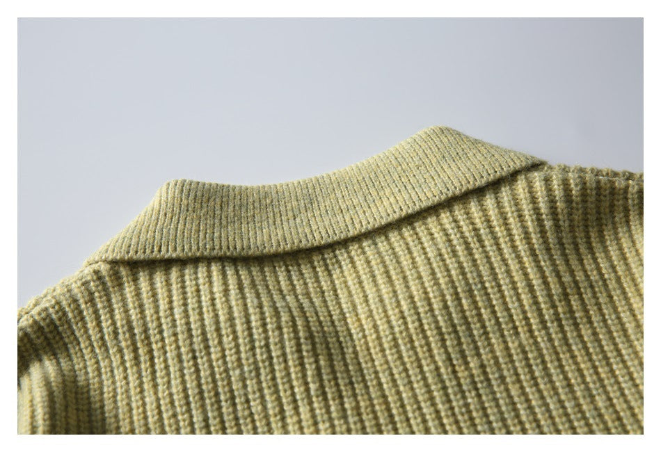 Close-up of a folded collar and ribbed knit fabric in pale olive-beige.