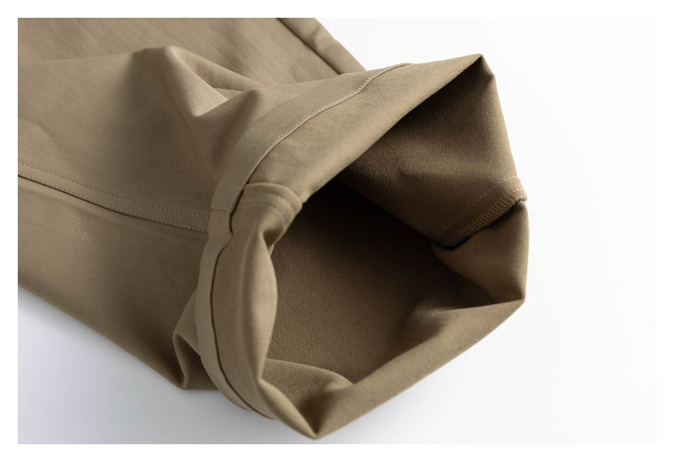 Close-up looking into the folded hem of a tan trouser leg, showing the inside and stitching.