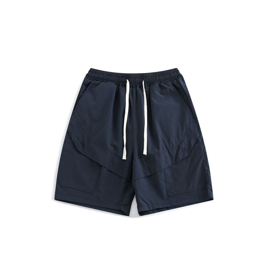 Navy shorts shown from the front, with white drawstrings, an elastic waistband, and large patch pockets.