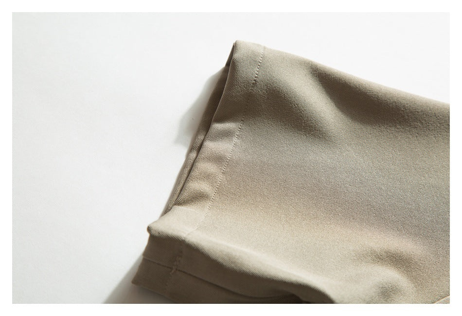 Close-up of a folded beige garment edge with a stitched seam.