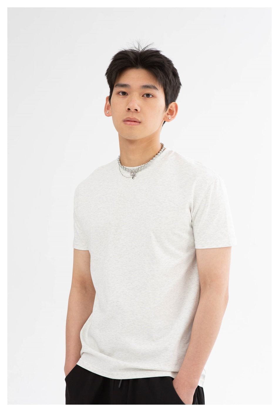 Close view of a model wearing a light heather-gray crew-neck T-shirt.