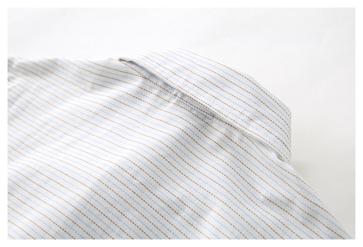 Close-up of the collar on a white shirt with fine blue and brown stripes.