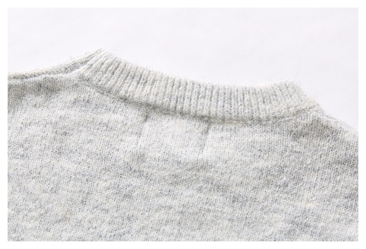 Close-up of the light gray marled sweater's ribbed neckline and shoulder seam.