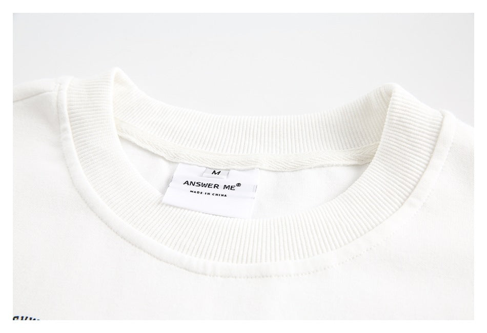 Close-up of a white sweatshirt's ribbed crew neck and sewn-in size and brand label.