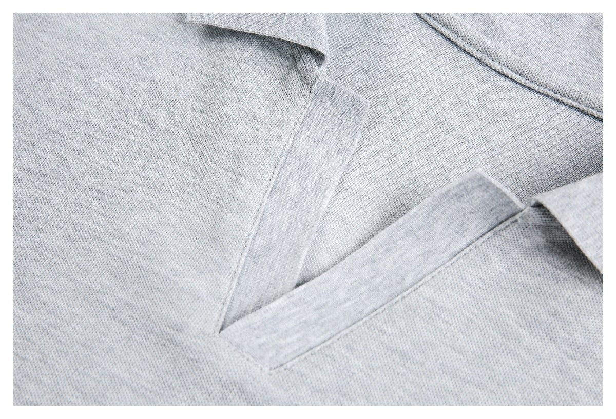 Close-up of the light gray polo shirt's textured fabric and V-shaped placket.