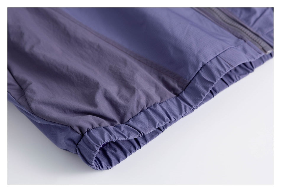 Close-up of a lavender garment's gathered elastic edge beside a zipper.