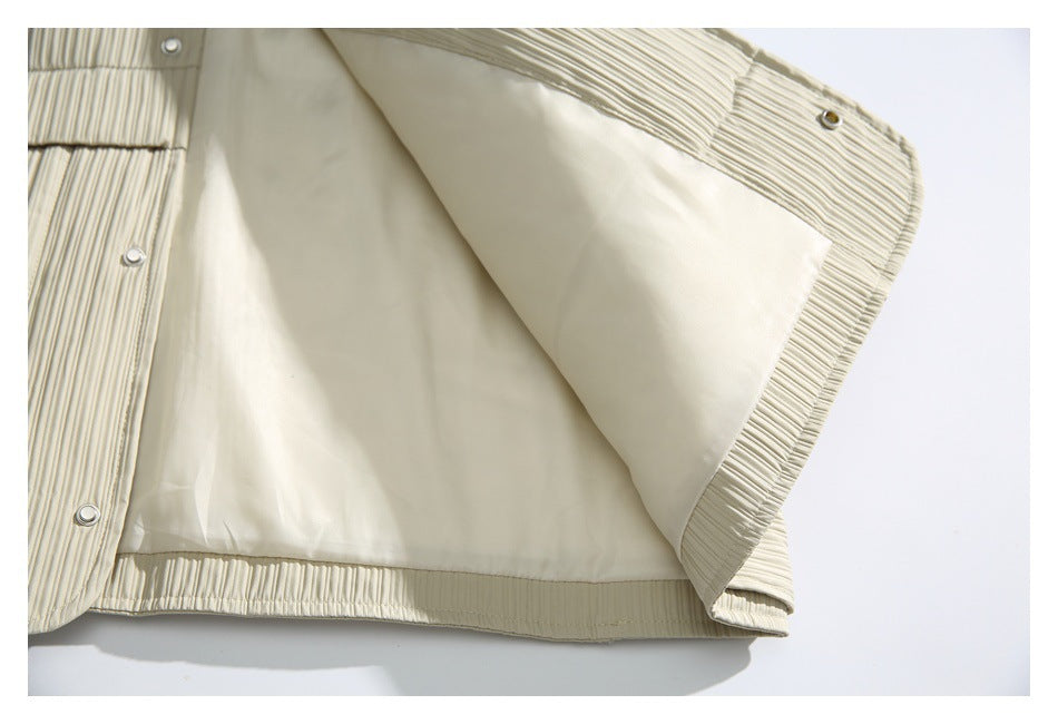 The ivory ribbed jacket is opened to show its smooth lining and metal snap fasteners.