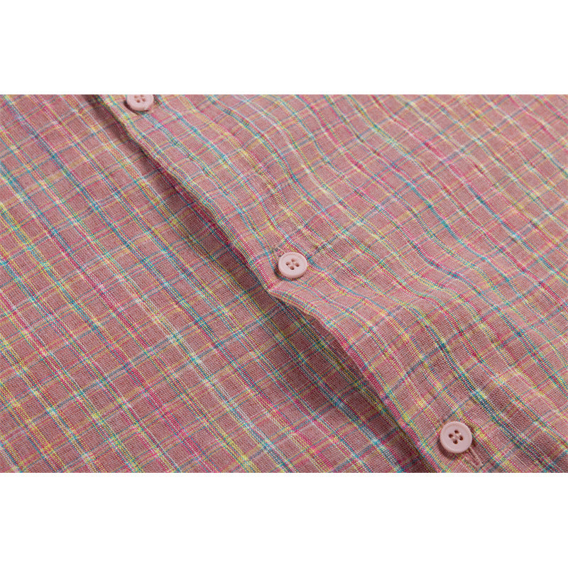 Close-up of pink plaid shirt fabric and front placket with pale pink buttons.