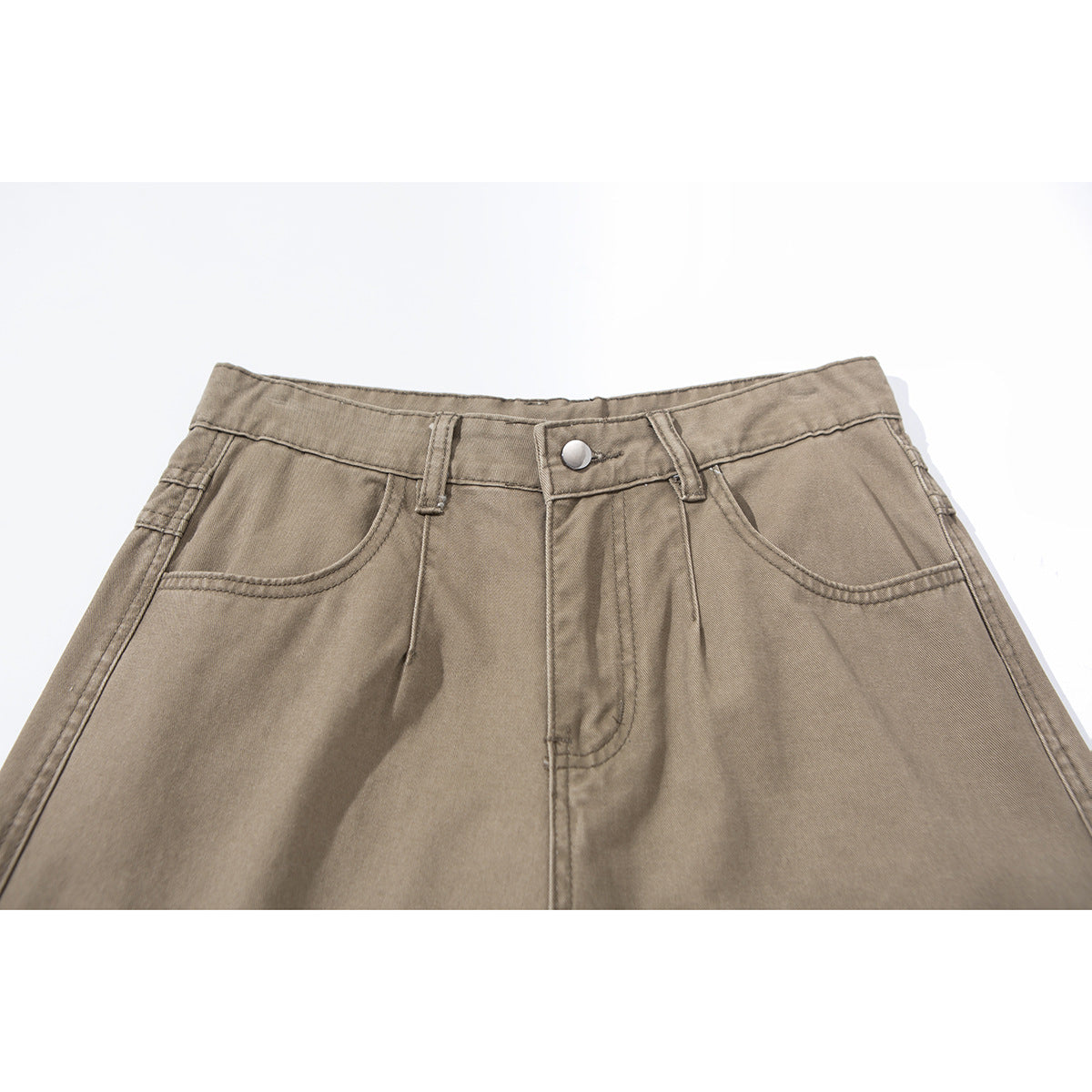 Close-up of taupe pants showing the front waistband, button, belt loops, fly, and curved pockets.