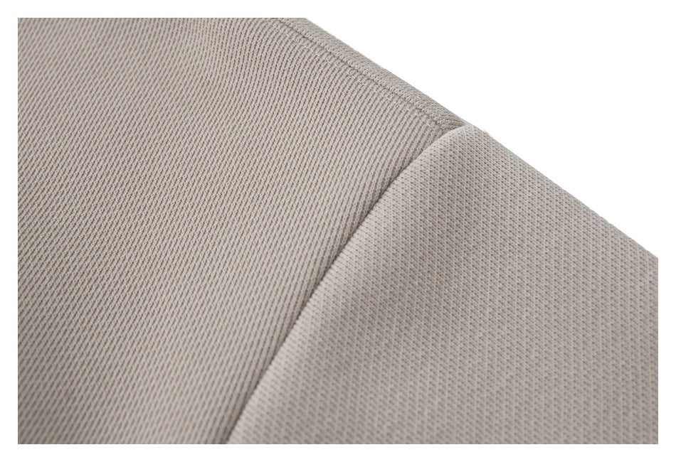 Close-up of the taupe sweatshirt's textured fabric and stitched shoulder seam.