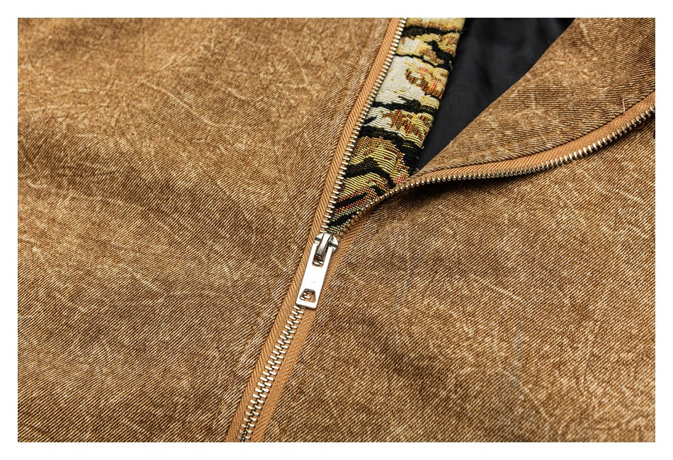 Close-up of a brown garment's metal zipper, with patterned trim and dark lining visible.