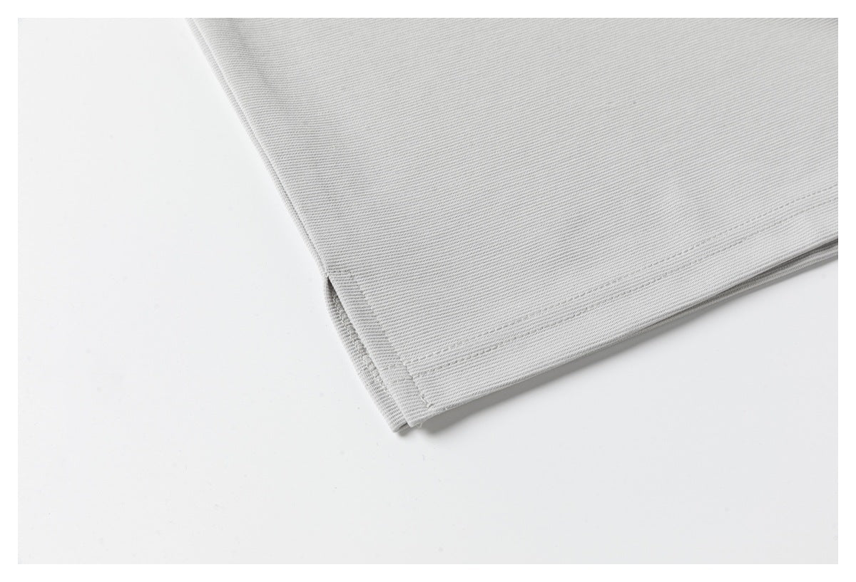 Close-up of the light gray polo's folded lower hem and stitching.