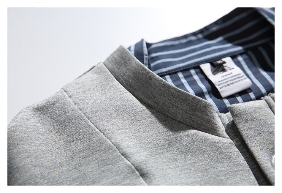 Close-up of a light gray garment collar over a navy striped inner collar and a small sewn label.