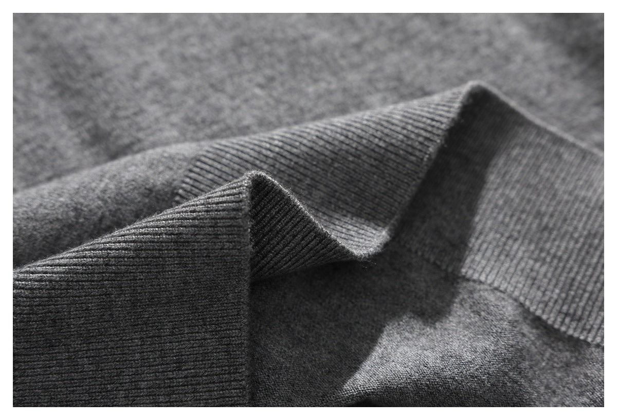 Macro view of the gray sweater's ribbed knit band folded to show its texture.