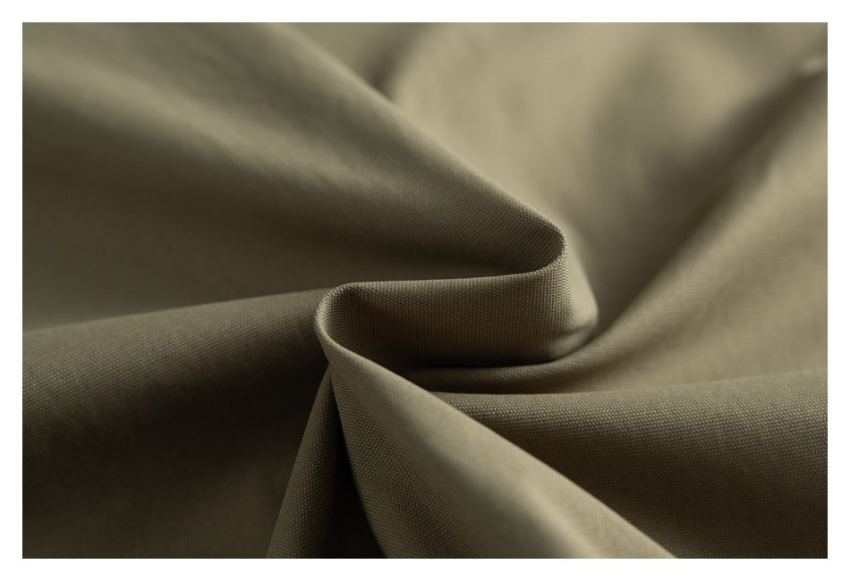Close-up of olive-taupe fabric with a fine woven texture, folded into soft curves.