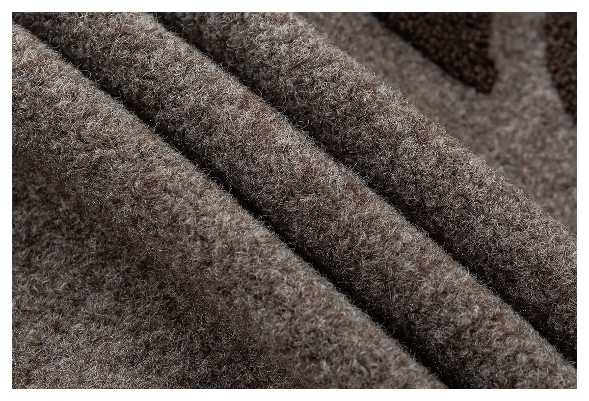 Close-up of thick, curly taupe-brown fabric folded into overlapping ridges.