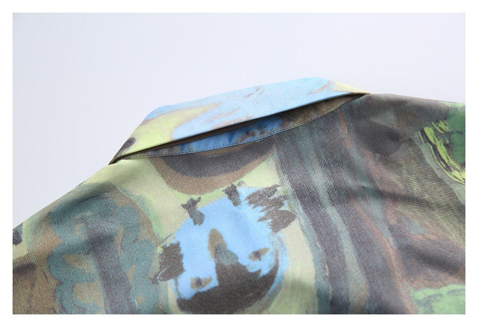 Close-up of a pointed collar and seam on a garment with a blue, green, brown, and gray abstract print.