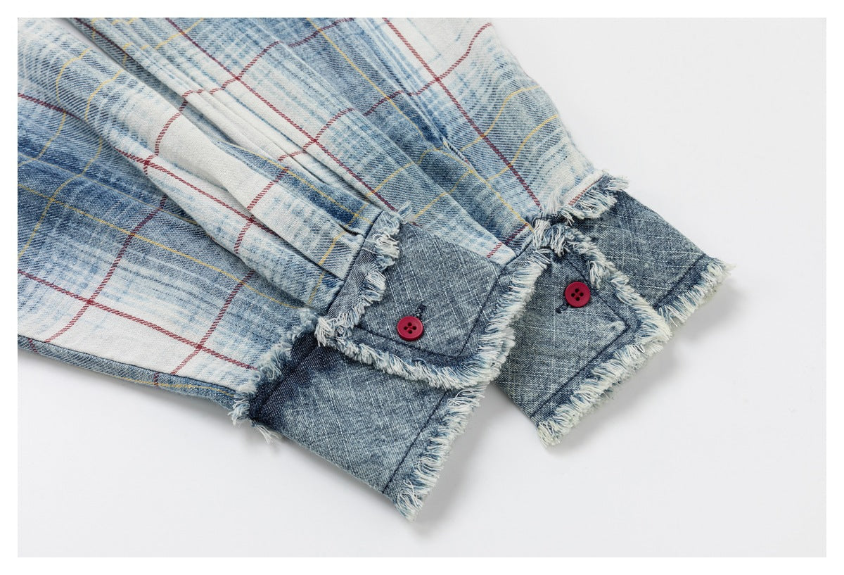 Close-up of the shirt's dark denim cuffs with red buttons and frayed trim beside plaid sleeves.