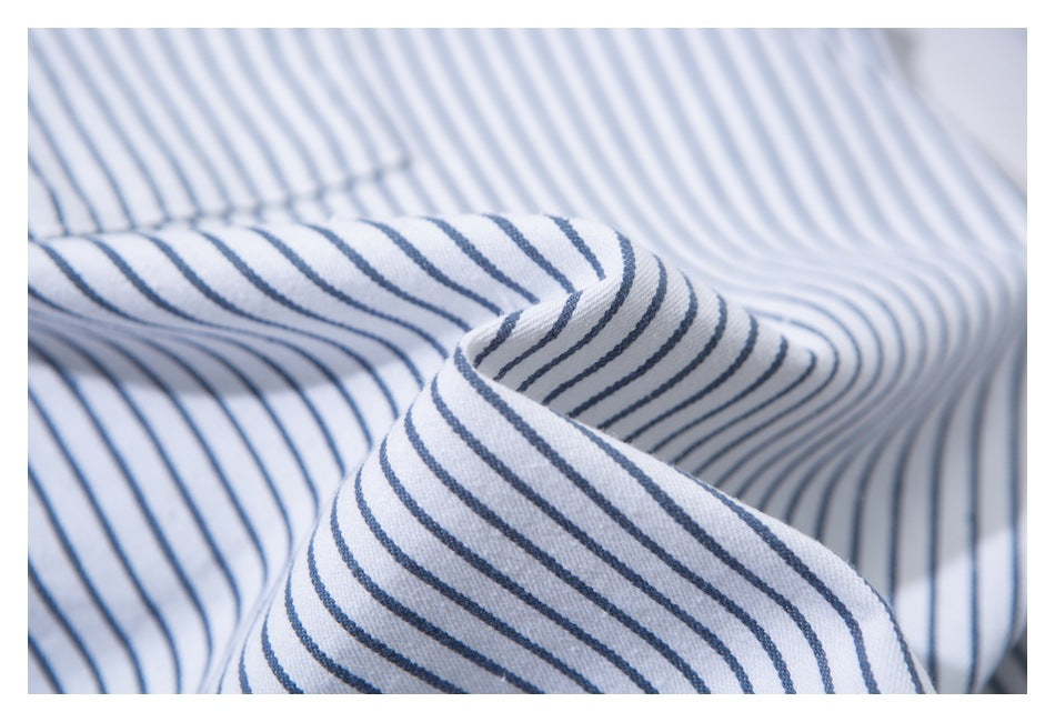 Close-up of a folded collar on a white shirt with narrow blue stripes.