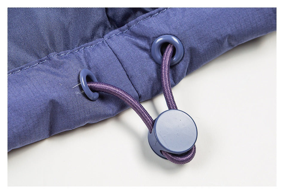 Close-up of a jacket edge with two eyelets, a purple drawcord, and a round plastic toggle.