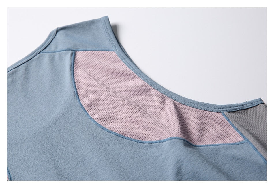 Close-up of a blue garment neckline with a curved pink grid-patterned insert and gray panel at the shoulder.