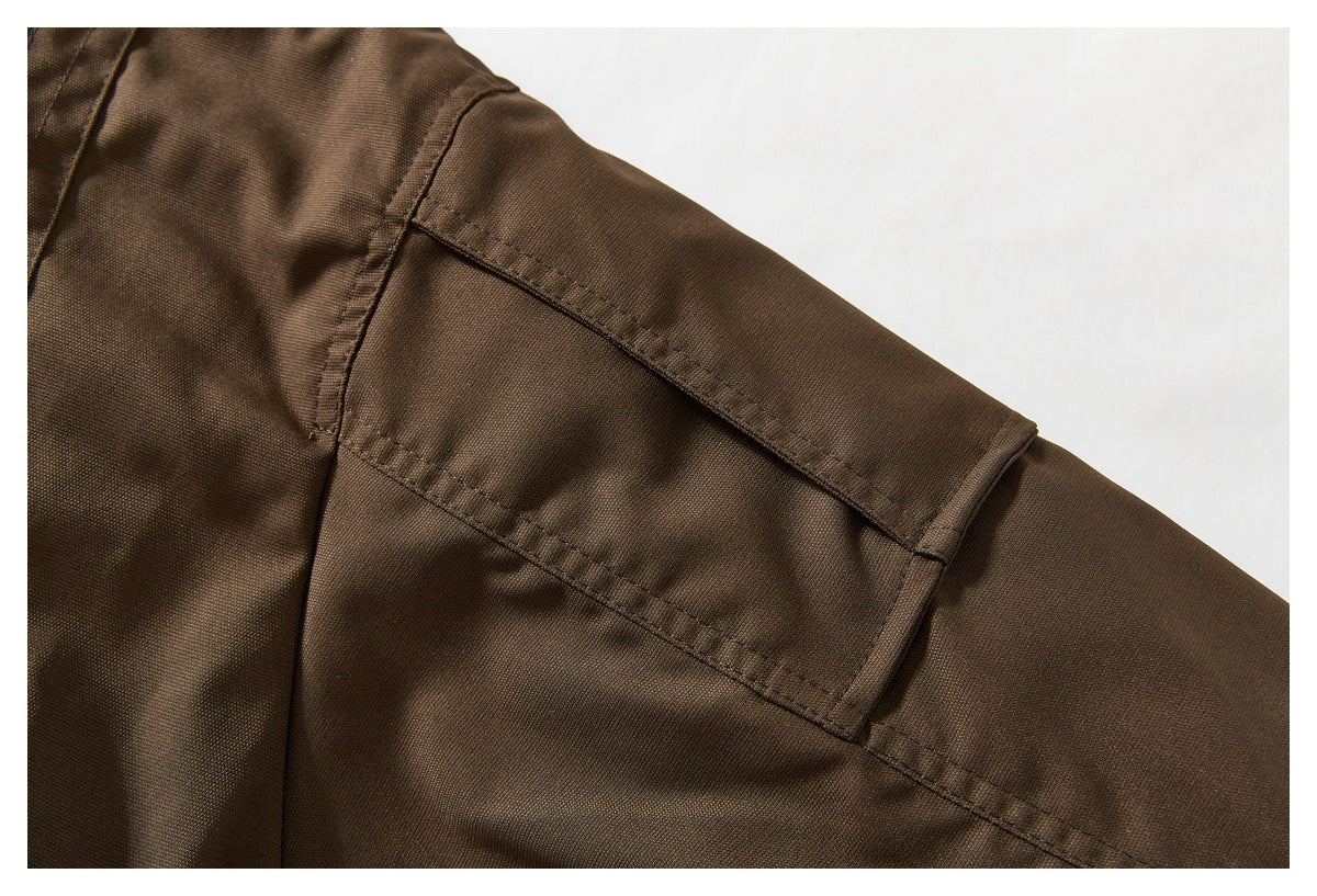 Close-up of the brown jacket's shoulder and sleeve with a stitched overlay panel.