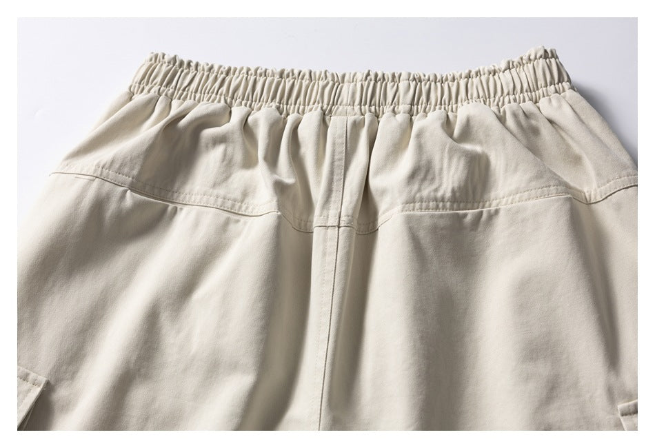 Back view of light beige shorts with an elastic waistband and rear seam details.