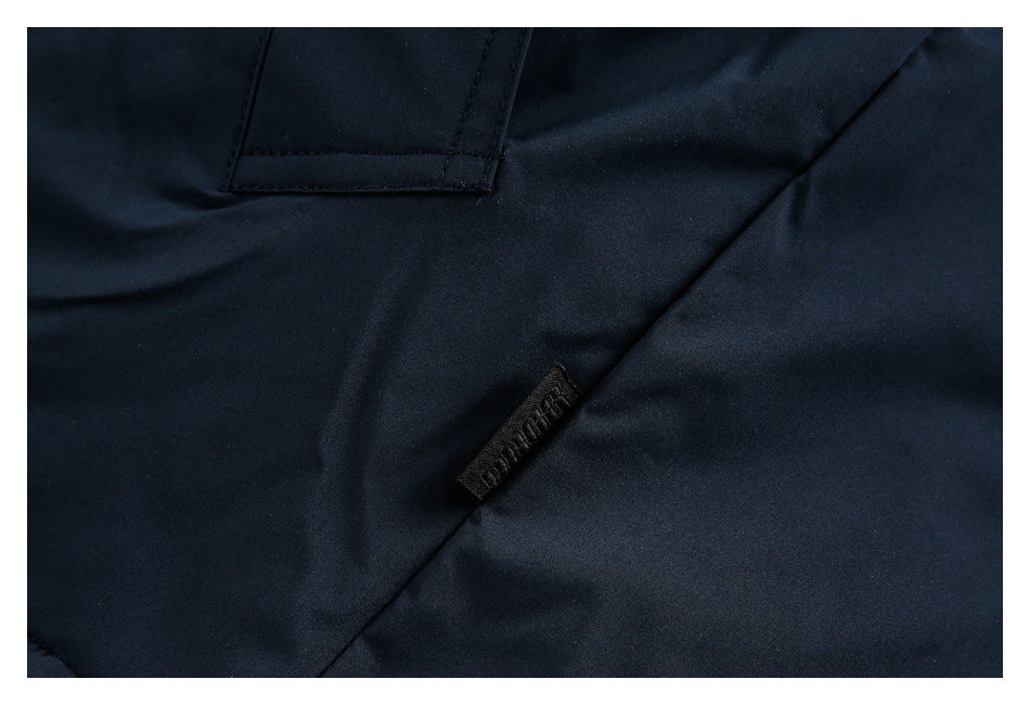 Close-up of dark navy garment fabric, a stitched pocket edge, and a small black tag.