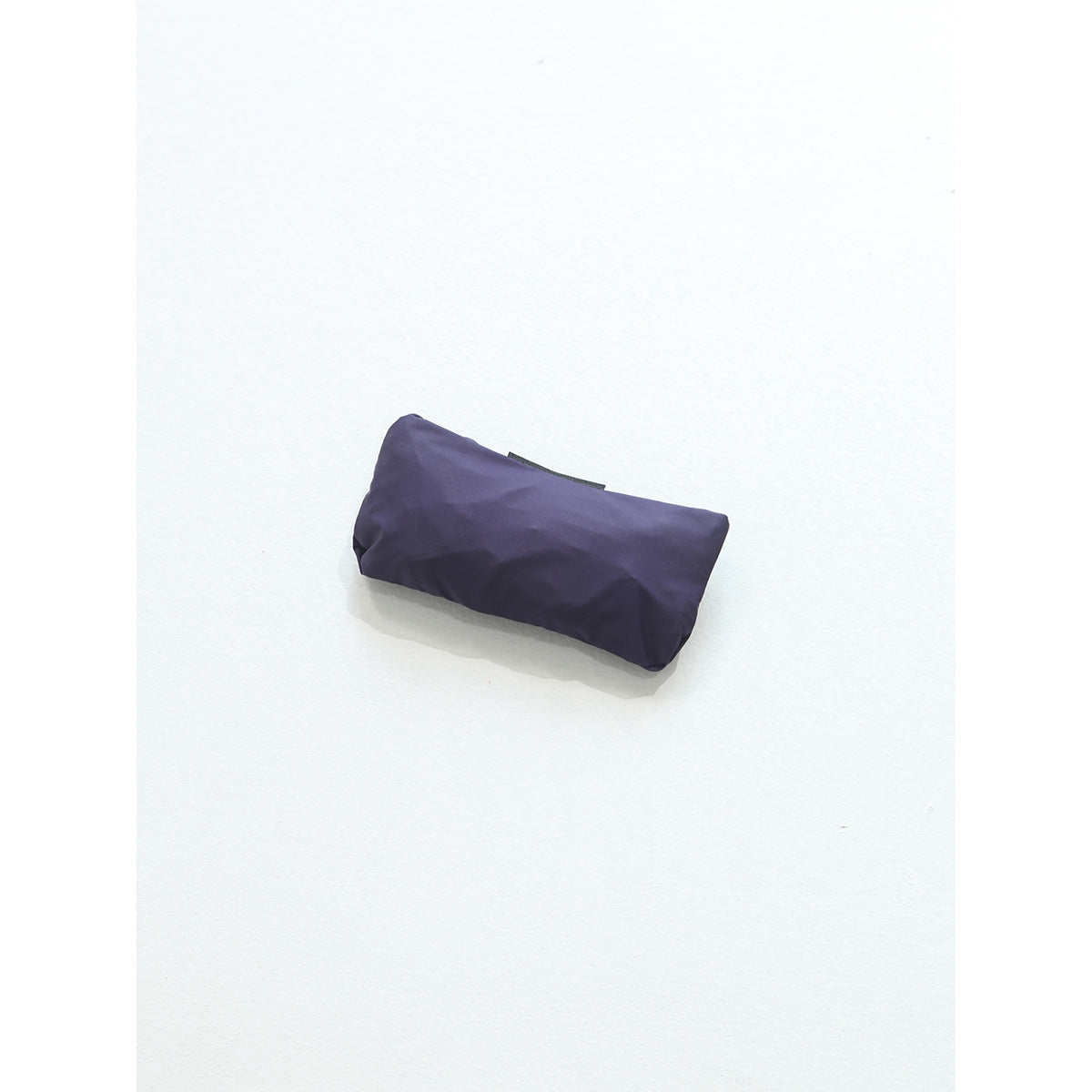 Compactly folded purple bag displayed against a plain white background.