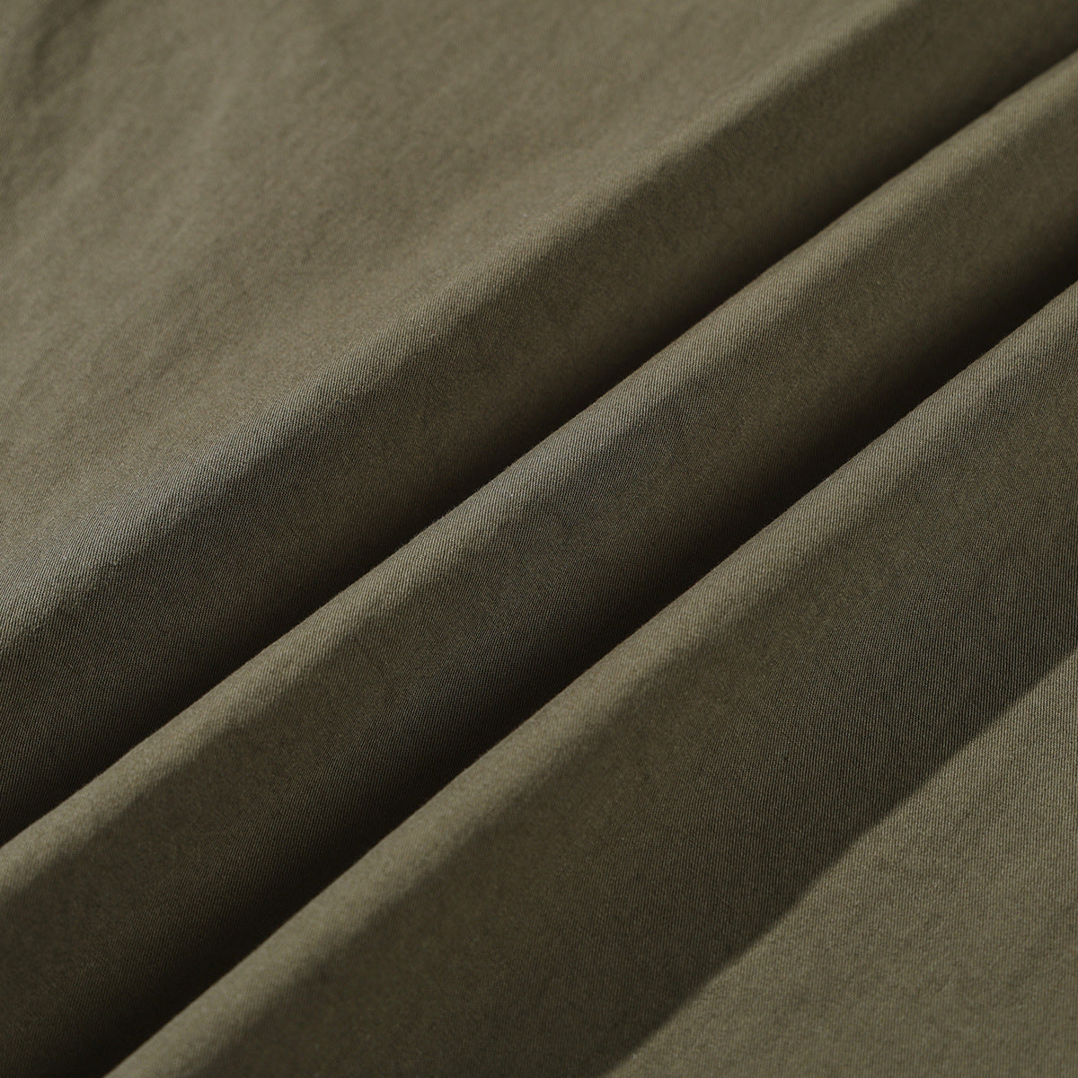 Close-up of olive fabric draped in soft folds.