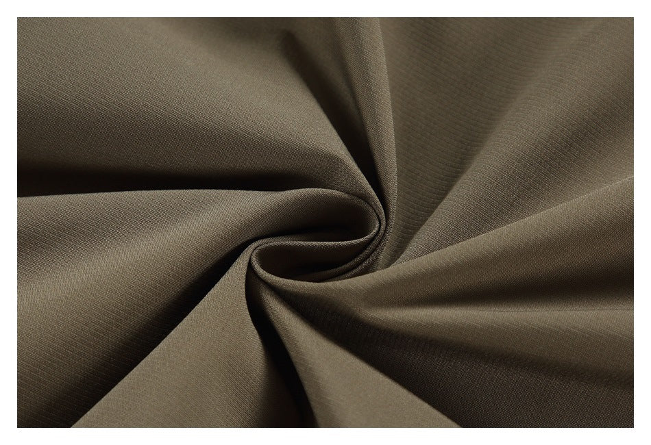 Close-up of olive-brown garment fabric gathered into soft folds.