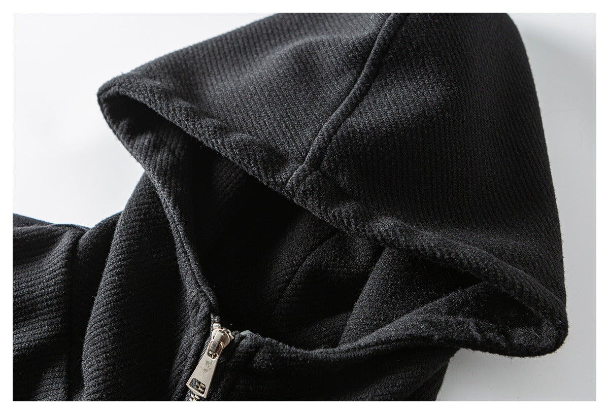 Close-up of the black jacket's hood, seam, and metal zipper pull.
